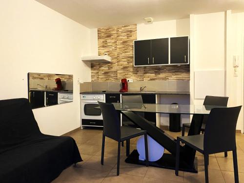 une cuisine avec une table et des chaises dans une pièce dans l'établissement Charmant T2 calme centre ville, à La Crau