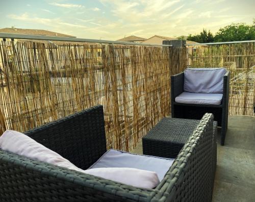 2 chaises en osier et une chaise sur la terrasse dans l'établissement Charmant T2 calme centre ville, à La Crau