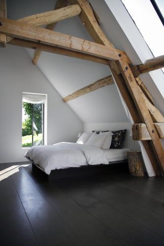 une chambre avec un grand lit dans un grenier dans l'établissement Etxeaona, à Blaru