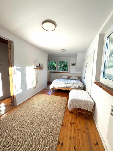 a bedroom with two beds and a rug at Domek nad Jeziorem Trzechowskim w lesie letniskowy na wsi in Iwiczno