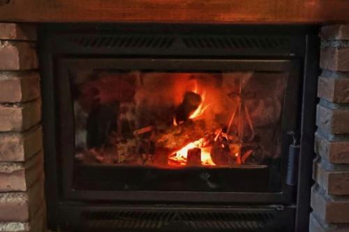 a brick fireplace with a fire in it at Le Casine di Tuscany Maremma Saturnia in Catabbio