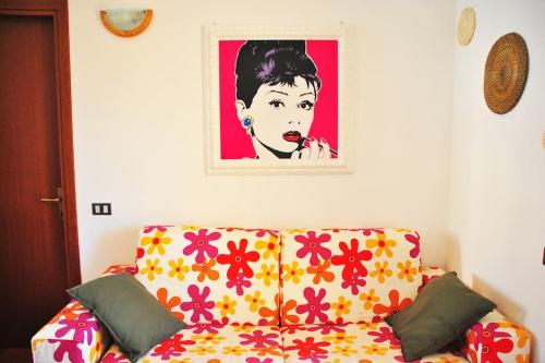 a couch in a living room with a picture on the wall at Le Casine di Tuscany Maremma Saturnia in Catabbio