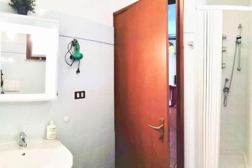 a bathroom with a wooden door next to a sink at Le Casine di Tuscany Maremma Saturnia in Catabbio