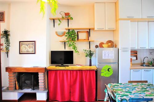 a kitchen with a table with a television on it at Le Casine di Tuscany Maremma Saturnia in Catabbio