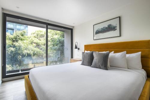 a bedroom with a large bed with a large window at Río Nazas 23 by Blueground in Mexico City