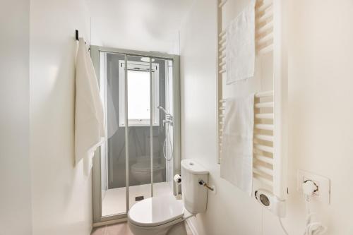 a white bathroom with a shower and a toilet at Camping Village Le Calanchiole in Capoliveri