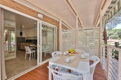 a room with a table and chairs on a balcony at Camping Village Le Calanchiole in Capoliveri