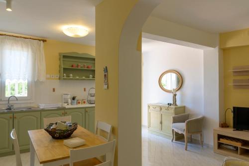 a kitchen and dining room with green cabinets and a table at ALTHEA HOUSES in Alinda