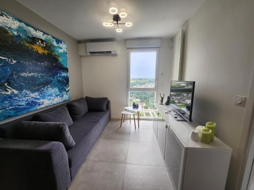 a living room with a couch and a large painting at Appartement T2 centre Rodez La Lutz in Rodez