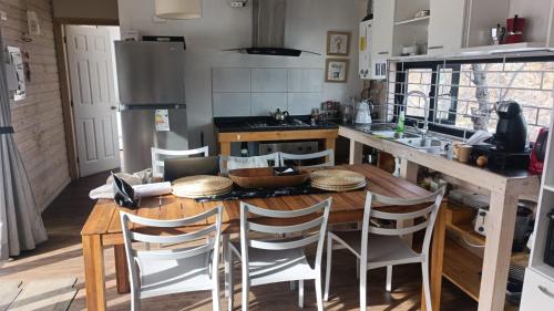 a kitchen with a wooden table and some chairs at REFUGIO REHUE in Nevados de Chillan