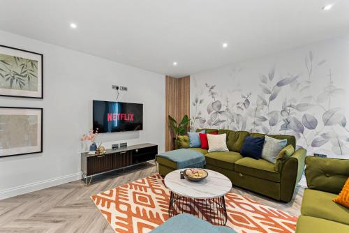 a living room with a couch and a tv at The Stylish Leeds Escape - Games Room in Leeds
