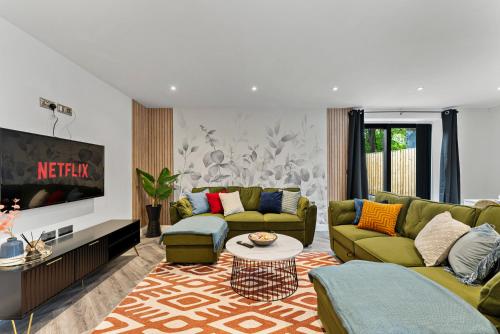 a living room with two couches and a tv at The Stylish Leeds Escape - Games Room in Leeds