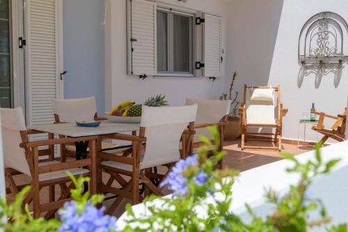 a patio with a wooden table and chairs at ALTHEA HOUSES in Alinda