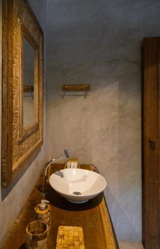 a bathroom with a sink and a mirror at Pousada Vila do Mar in Caraíva