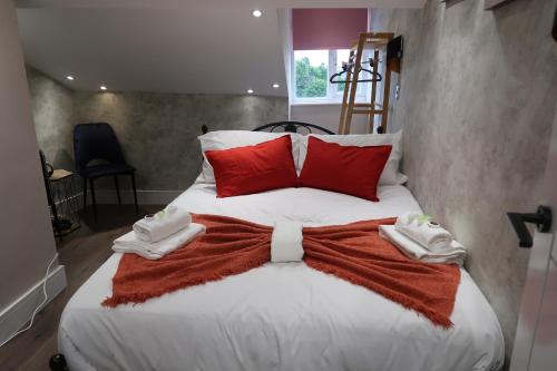 a large bed with red and white towels on it at The Loft At Sherborne's Historic Quarter Local in Sherborne
