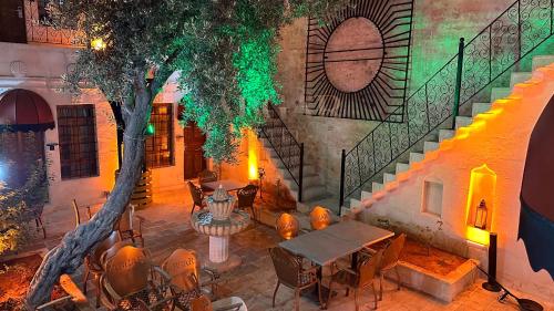 a patio with a table and chairs and a tree at ABGAR Otel in Sanlıurfa