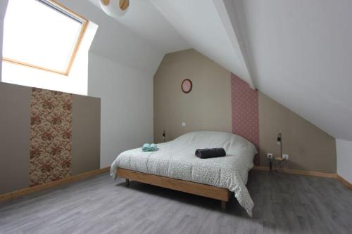 une chambre avec un lit dans un grenier dans l'établissement La Maison du Pont, à Vred