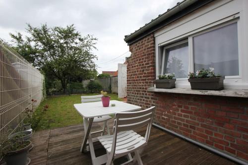 d'une petite table et de chaises blanches sur un balcon. dans l'établissement La Maison du Pont, à Vred