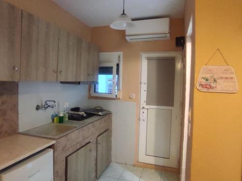 a kitchen with wooden cabinets and a sink at Happy Home in Agia Triada