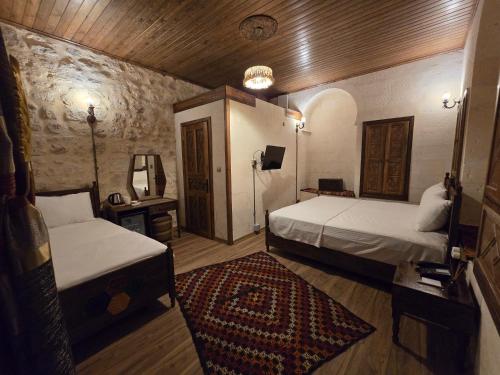 a bedroom with two beds and a rug at ABGAR Otel in Sanlıurfa
