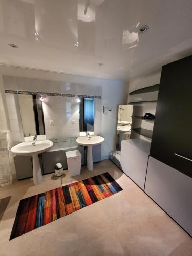 a bathroom with two sinks and two mirrors and a rug at villa deloro in Orbey