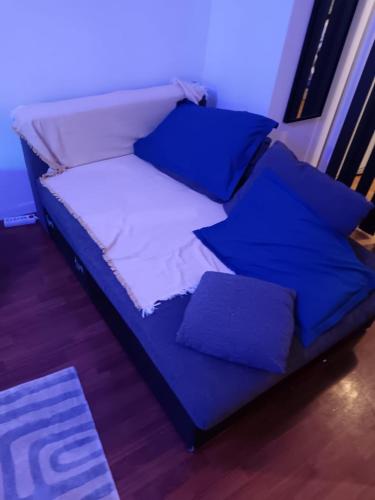 - un lit avec des draps et des oreillers bleus dans l'établissement studio, à Saint-Denis