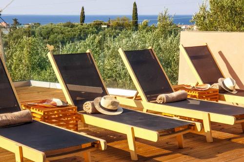 three picnic tables with hats on them on a deck at Villa de la Vita in Katastárion
