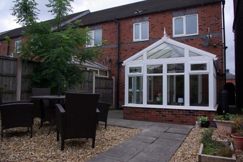 a white conservatory in the back of a house at Portland Mews - 3 Bed Holiday Home By Premier Serviced Accommodation in Leek