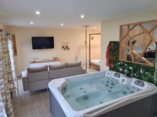 a living room with a jacuzzi tub at Les suites d'Élise - Gîte Agathe in Grumesnil