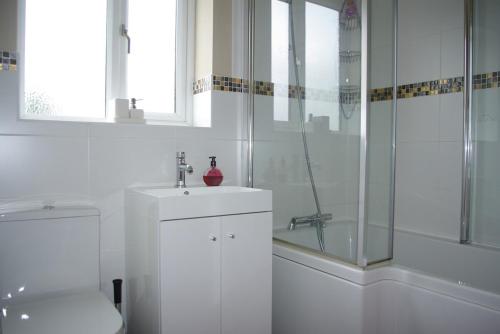 a bathroom with a shower and a sink and a toilet at Portland Mews - 3 Bed Holiday Home By Premier Serviced Accommodation in Leek