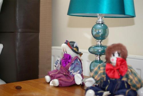 two stuffed animals sitting on a table next to a lamp at Portland Mews - 3 Bed Holiday Home By Premier Serviced Accommodation in Leek