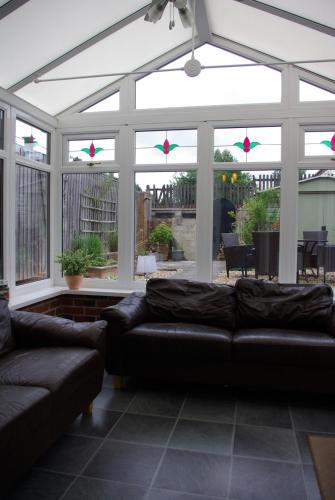 a living room with couches and a large window at Portland Mews - 3 Bed Holiday Home By Premier Serviced Accommodation in Leek