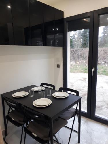 une table noire avec des chaises et des assiettes dessus dans l'établissement Ali, à Savigny-le-Temple