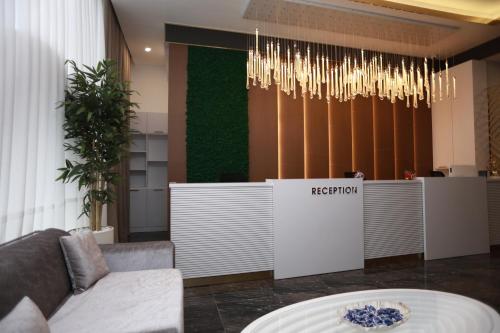 a lobby with a reception desk and a chandelier at IsraHotel Dushanbe in Dushanbe