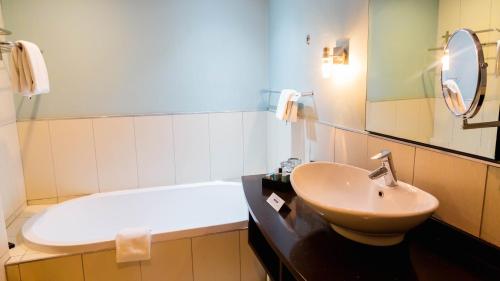 a bathroom with a sink and a toilet and a tub at Phakalane Golf Estate Hotel & Convention Centre in Gaborone