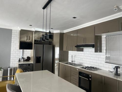 a kitchen with a white counter top and a refrigerator at Vic's place - With backup power in Sandton