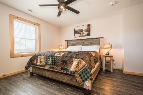 Un dormitorio con una cama y un ventilador de techo. en Mountain Crest Lodge, en McHenry