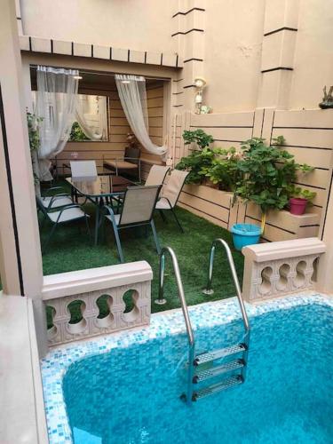 a swimming pool on a balcony with a table and chairs at Magnifique villa avec piscine privée in Alger