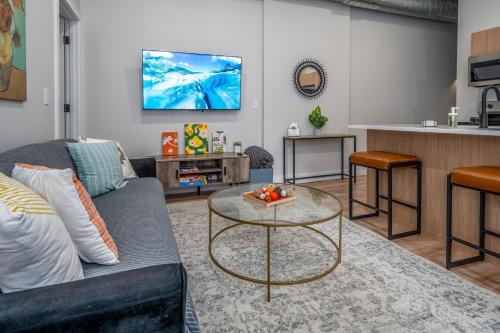 a living room with a couch and a table at Prime OTR, 3 Lux Queen Beds, Two 55in TVs, Steps to TQL, Findlay Market, Light Rail, Fast Wifi in Cincinnati
