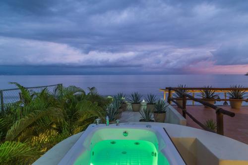 a hot tub on a balcony with the ocean at Hotel Ysuri Bucerias in Bucerías