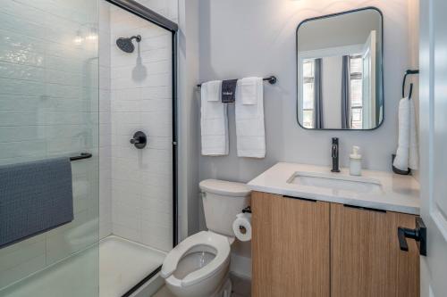 a bathroom with a toilet and a sink and a shower at Prime OTR, 3 Lux Queen Beds, Two 55in TVs, Steps to TQL, Findlay Market, Light Rail, Fast Wifi in Cincinnati