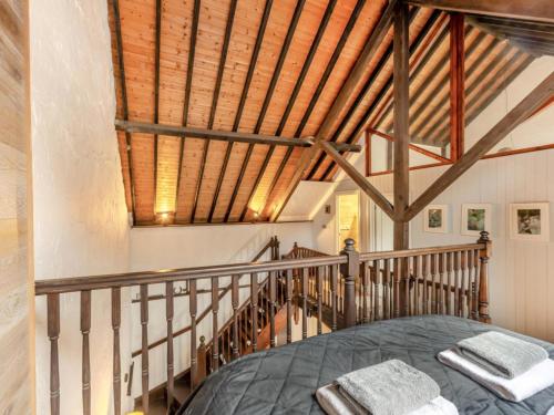 a bedroom with a bed and a wooden ceiling at The Old Smithy in Lynton
