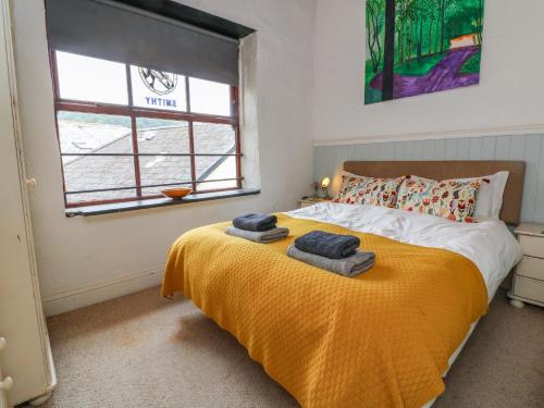 a bedroom with a bed with towels on it at The Old Smithy in Lynton