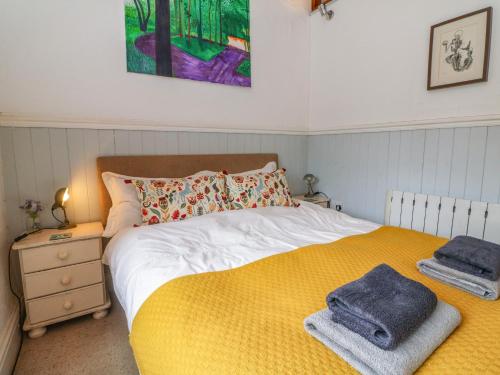a bedroom with a bed with towels on it at The Old Smithy in Lynton