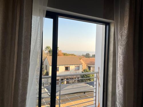 a window with a view of a balcony at Cozy Retreat in Carlswald 229 in Midrand