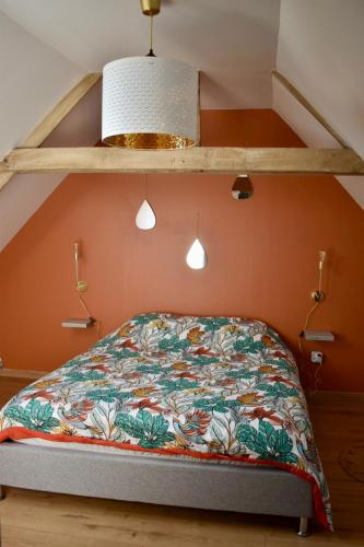 - un lit avec une couette colorée dans l'établissement Au cœur du marais,Le léonin, à Saint-André-de-Bohon