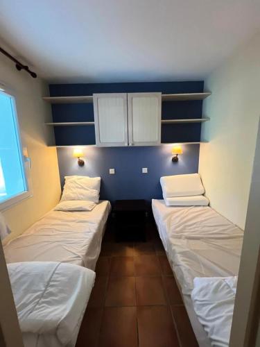 - 3 lits dans une chambre aux murs bleus et blancs dans l'établissement Le Domaine du Golf de Pinsolle - maeva Home - Appartement 2 pièces 4 personnes - Prestige MAE-6651, à Soustons