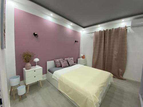 Un dormitorio con una cama blanca y una pared rosa. en Villa Verdi, en Biograd na Moru