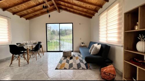 a living room with a blue couch and a table at Cabaña Linda y acogedora in Guarne