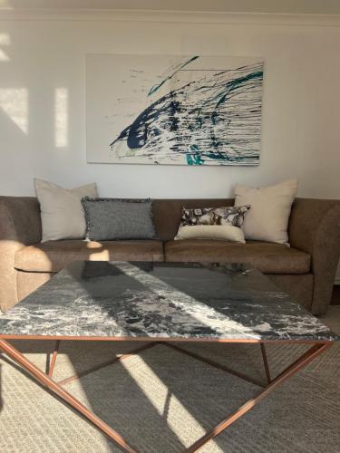a living room with a couch and a table at Orchid on Main - Valley of 1000 hills in Drummond